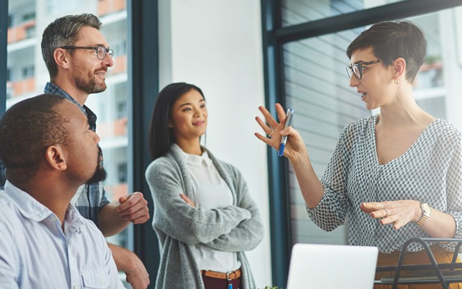 Group Of Colleagues Having A Discussion In A Modern Office