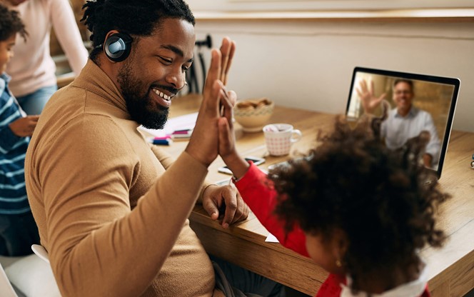 Happy Black Father Giving High Five To His Daughter While Working At Home