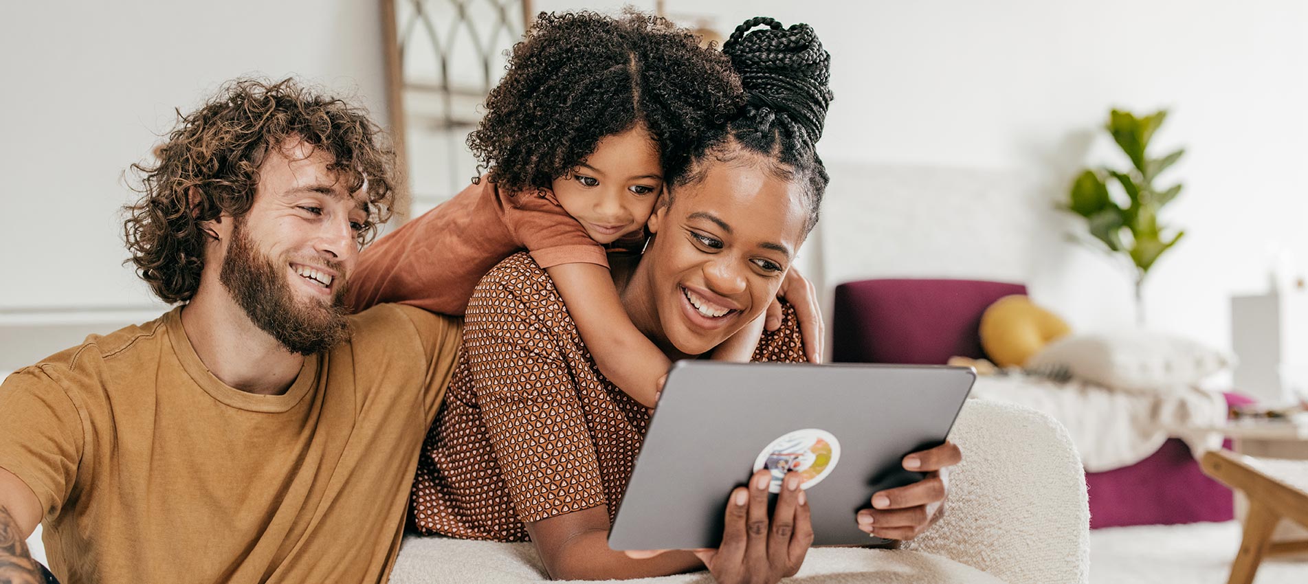 Smiling Parents And Daughter At Home Watching Online Movie Together