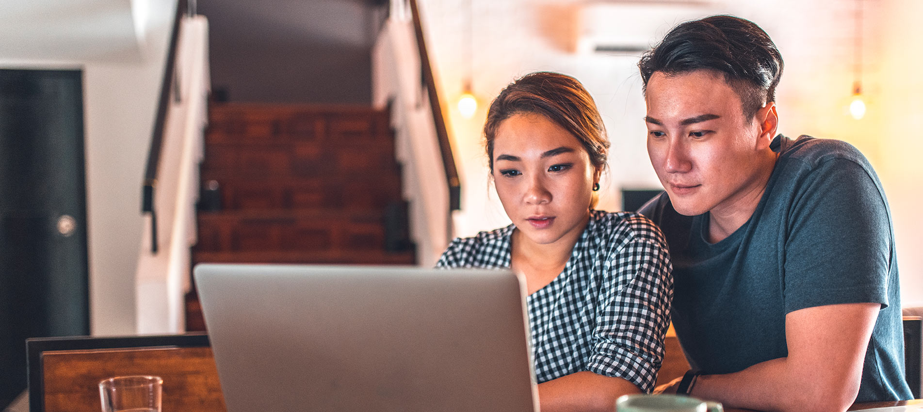 Asian Couple Using Laptop Working On Their Finances At Home