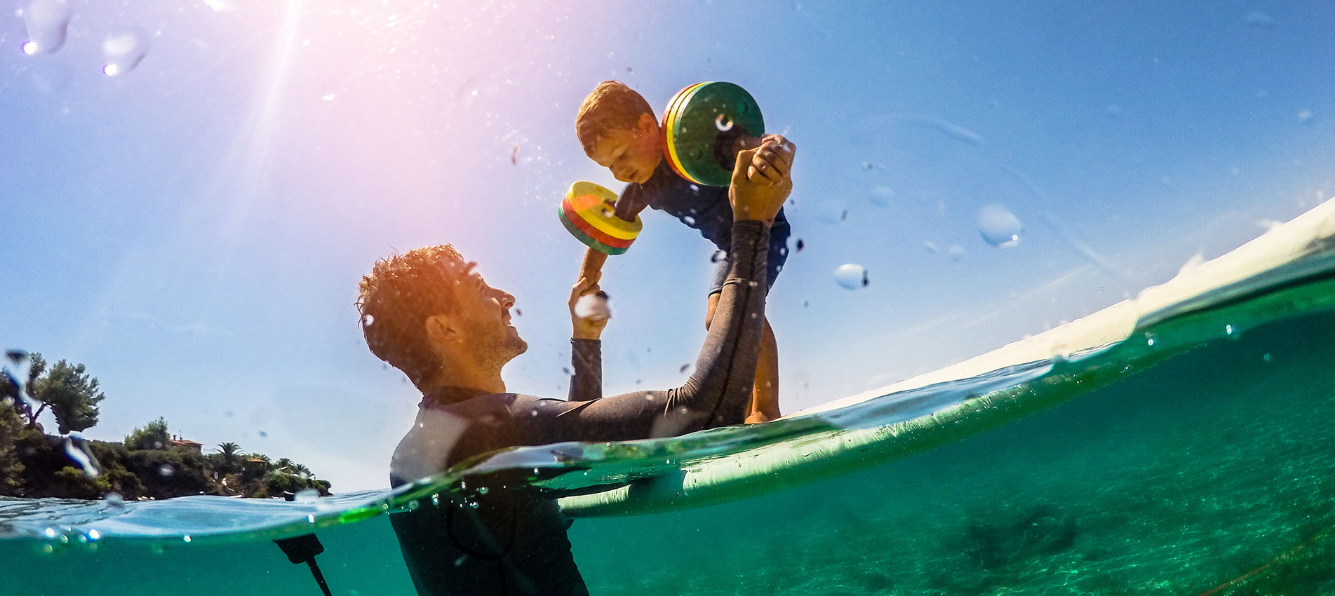Father And Son Playing In Water