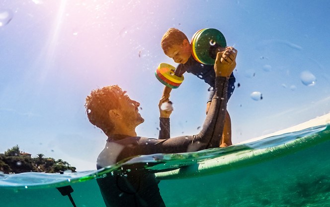 Father And Son Playing In Water