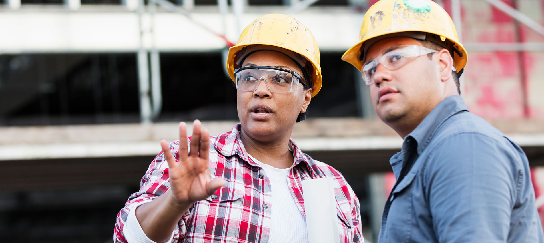Two Workers Talking At A Construction Site, Looking