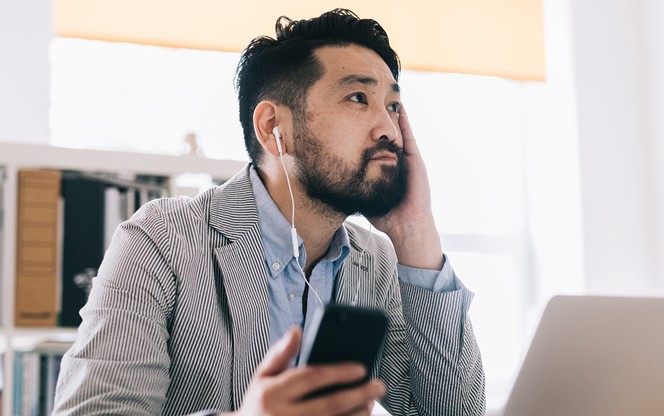 Asian Businessman Listening Educational Audiobook And Making Notes In The Laptop