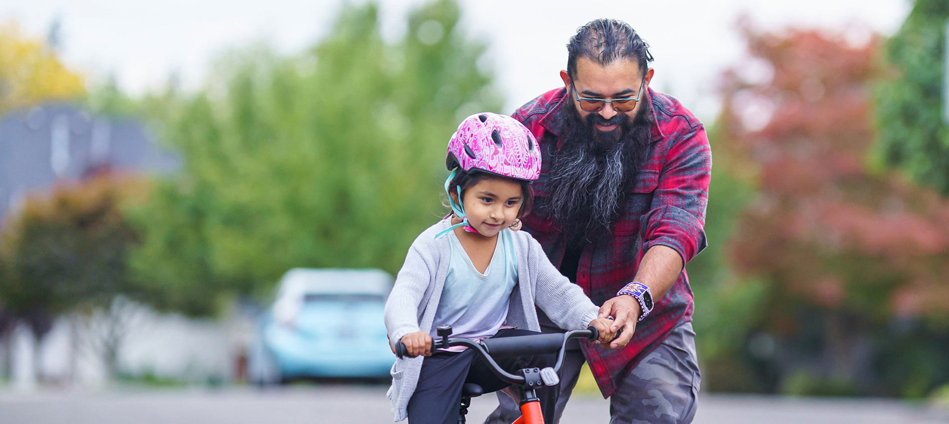 Native American Dad Helping His Young Daughter Learn To Ride A Bike