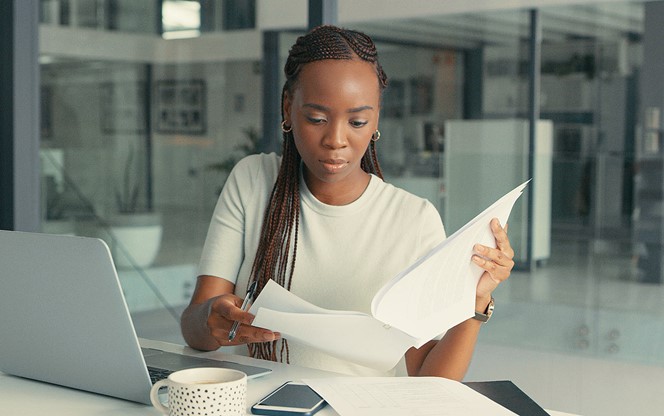 Shot Of A Beautiful Young Woman Doing Some Paperwork In A Modern Office