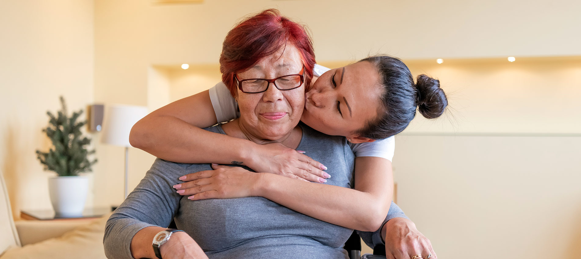 Senior Woman In A Wheelchair Is Receiving Treatment By Her Careful Daughter