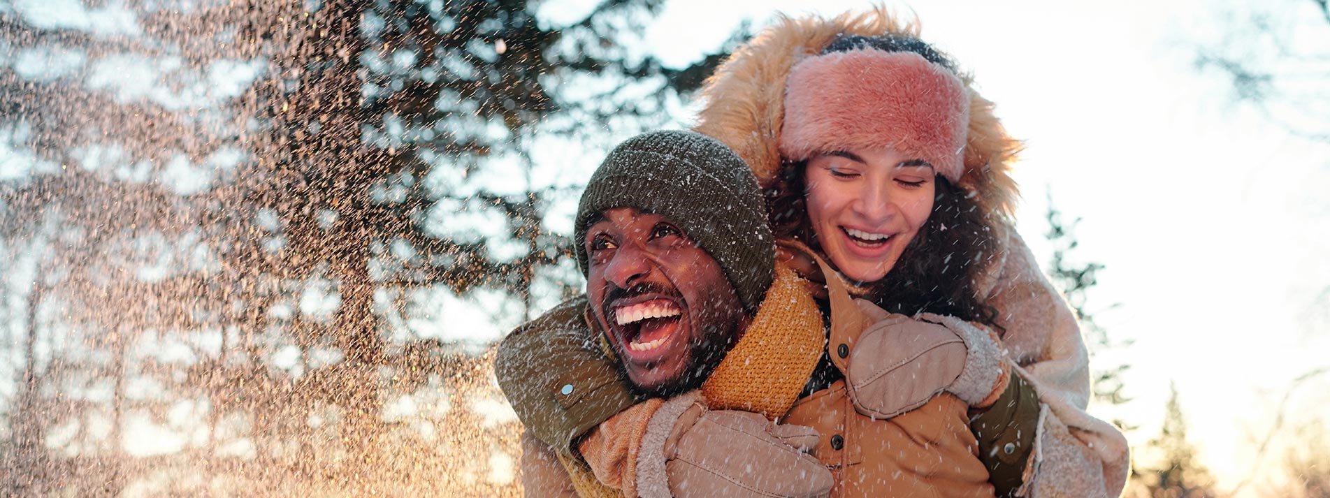 Cheerful Multiracial Couple In Winterwear Laughing While Girl Embracing Her Boyfriend