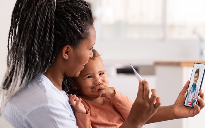 Woman And Baby Daughter Using A Smartphone To Communicate With The Doctor