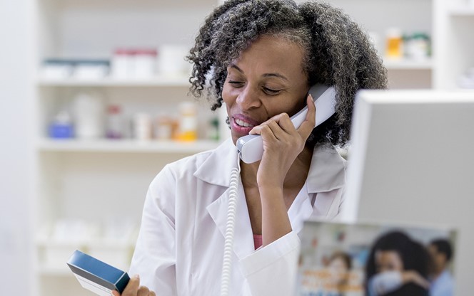 Pharmacist Uses Phone In Pharmacy