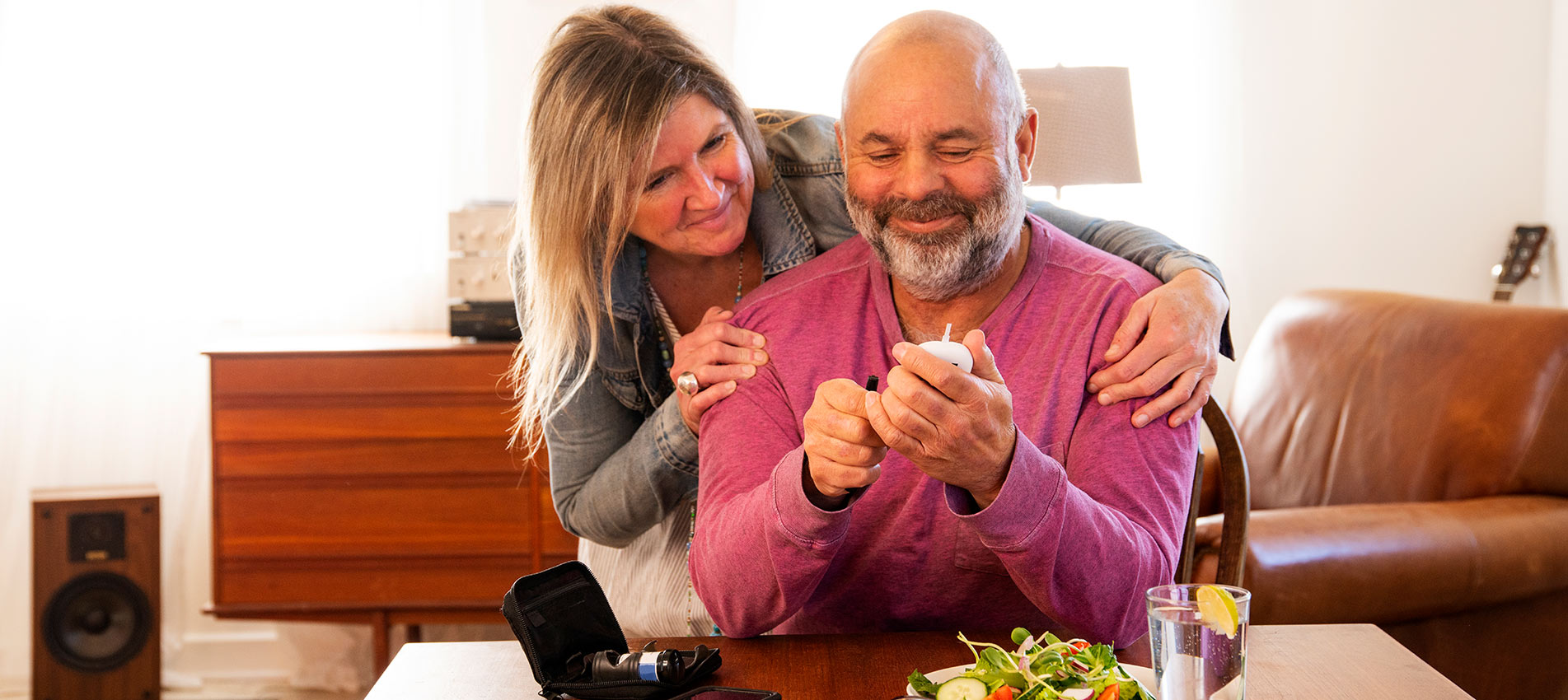 A Diabetic Patient Checking His Blood Sugar At Home With The Support Of His Wife