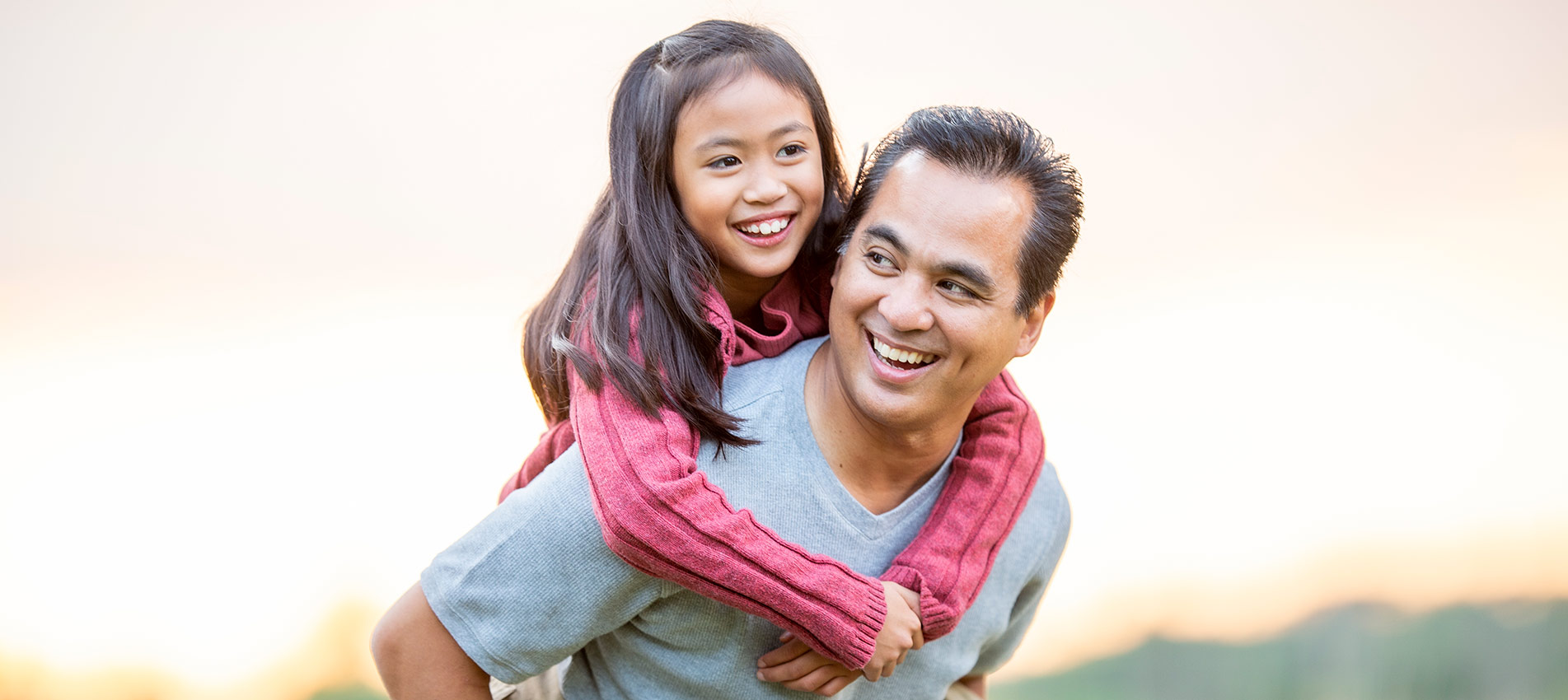 Father Giving His Daughter A Piggyback Ride