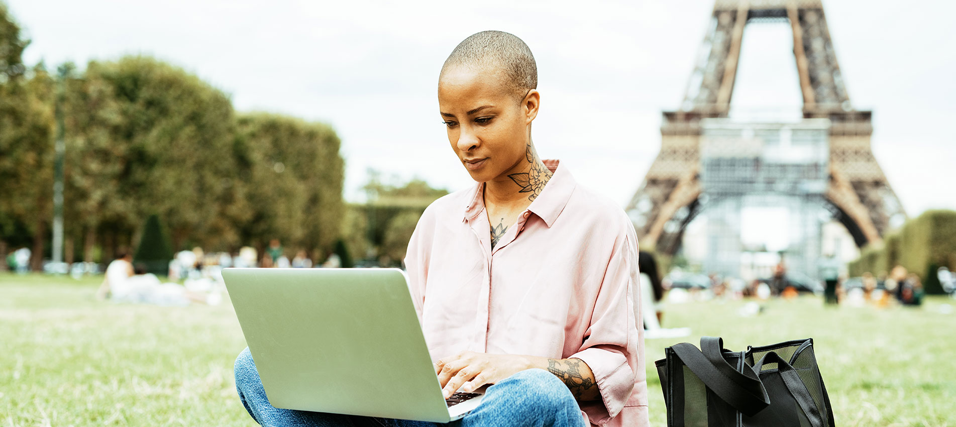 Mixed Race Woman Working On Laptop Outdoor By The Eiffel Tower