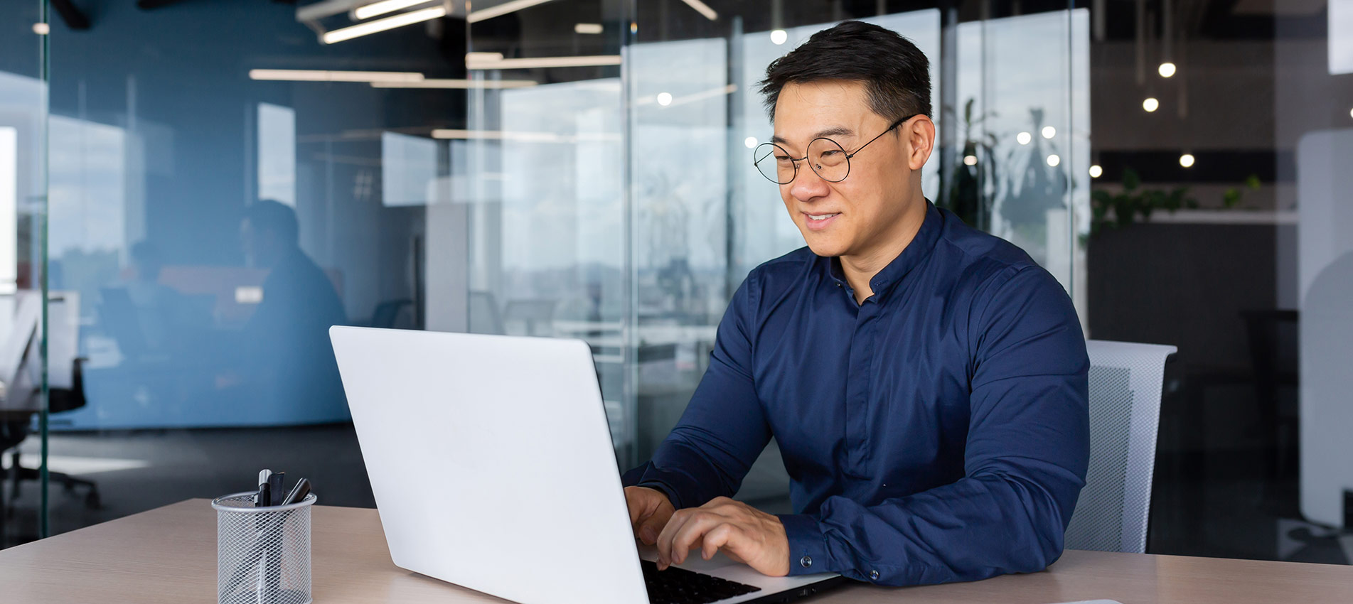 Asian Man Working Inside Office Using Laptop