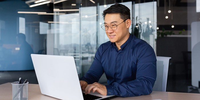Asian Man Working Inside Office Using Laptop