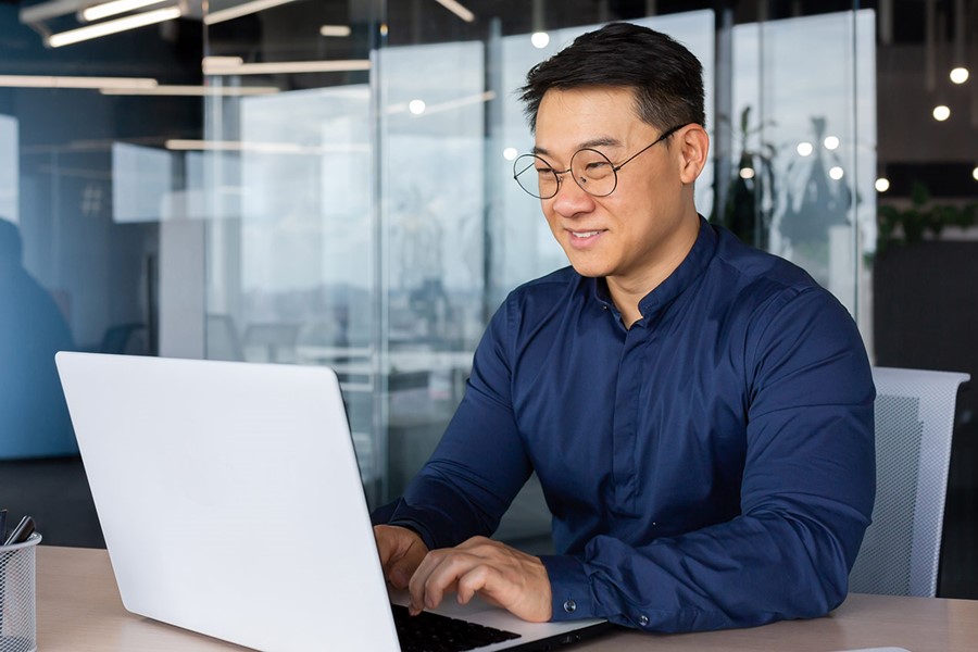 Asian Man Working Inside Office Using Laptop