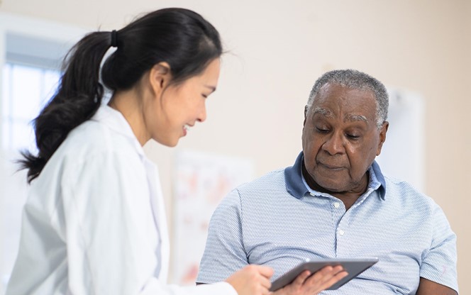 Black Senior Man Listens To His Doctor Talk About His Treatment Plan
