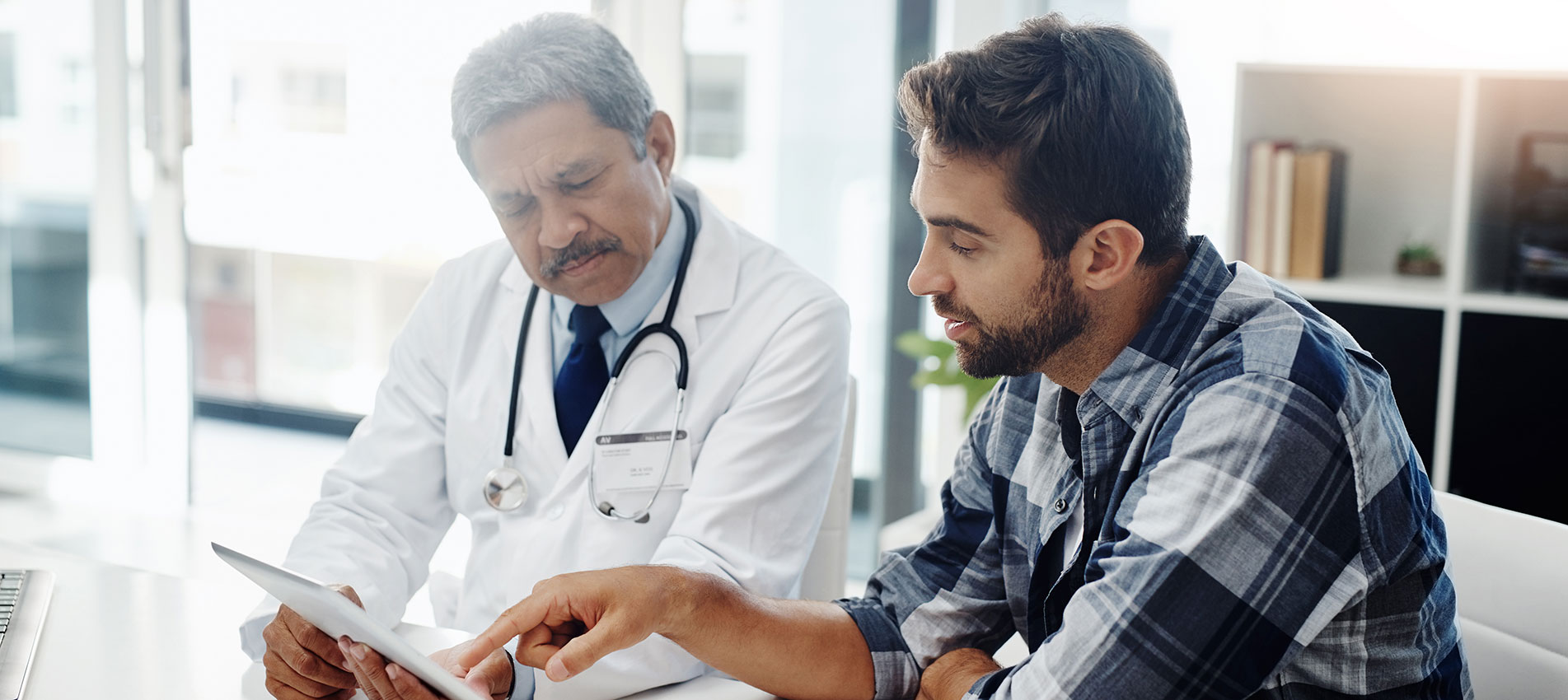 Male Doctor And Patient Having A Discussion In The Doctors Office Before A Checkup