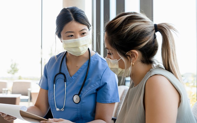 Female Nurse Asks Young Woman Questions For Record