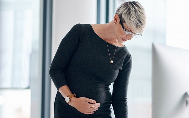 Pregnant Businesswoman Writing Notes In An Office