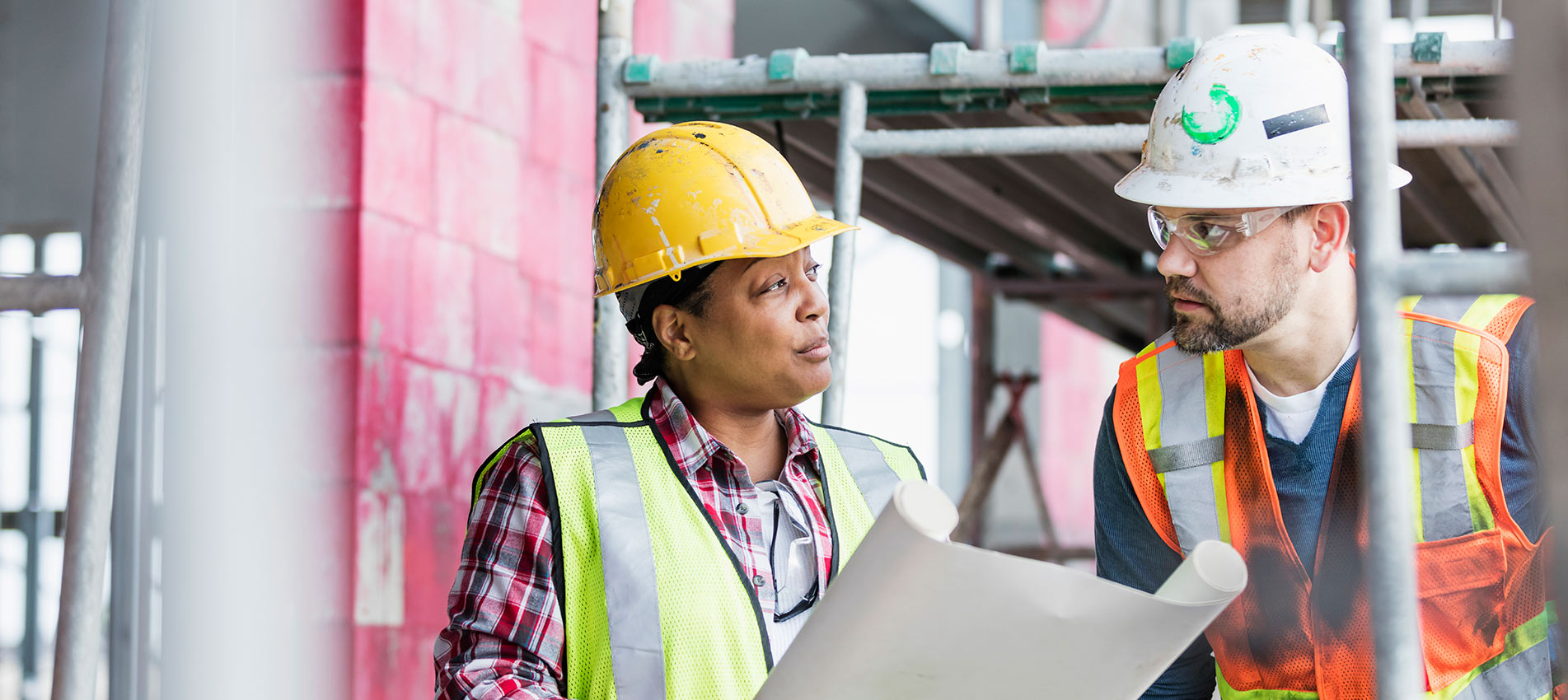 Workers At Construction Site Looking At Plans