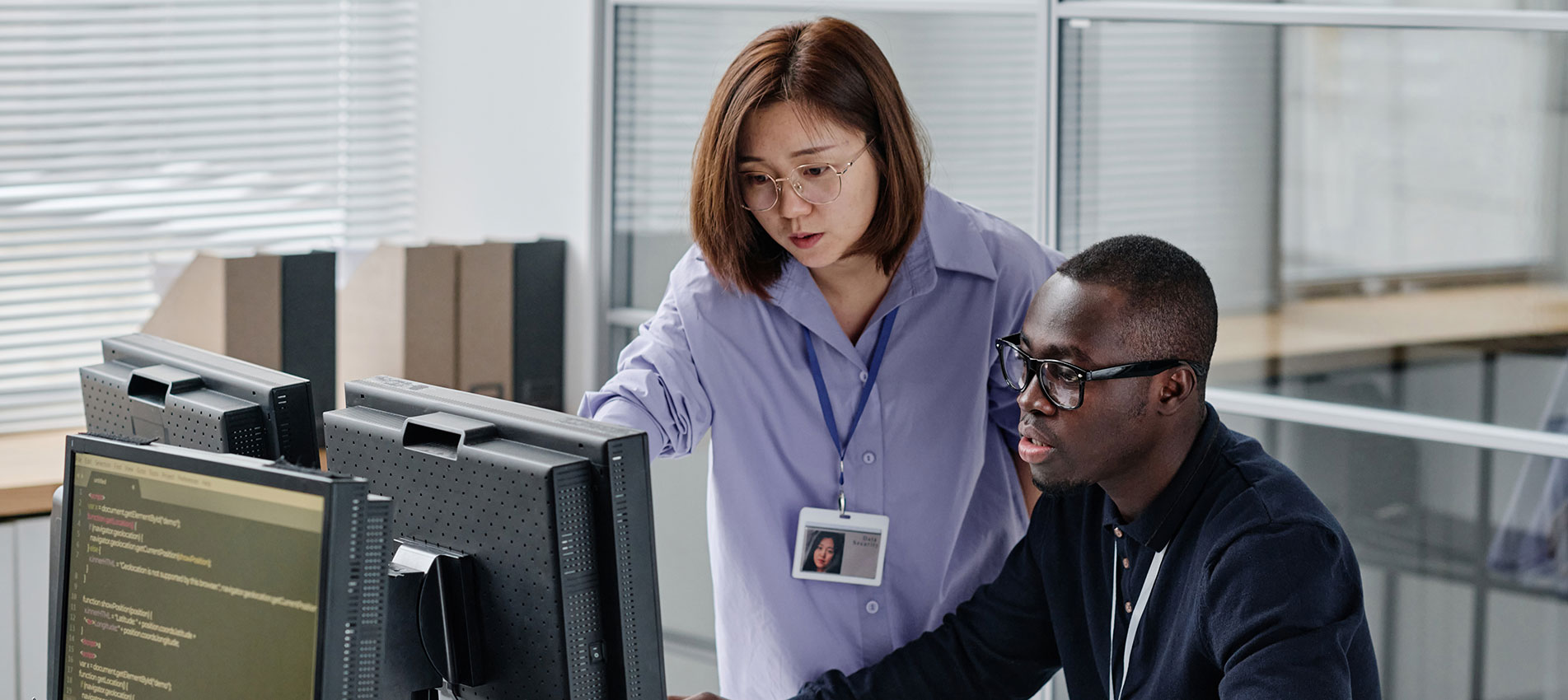 Asian Woman Discussing New Software With Colleague