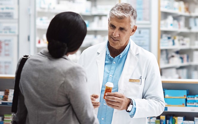 Pharmacist Explaining Medication To Woman