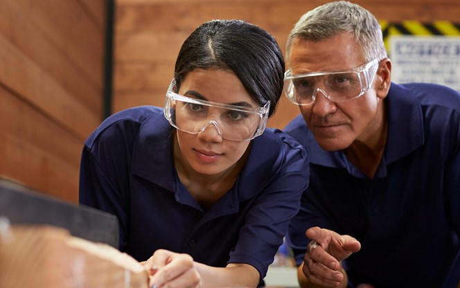 Carpenter Training Female Apprentice To Use Plane