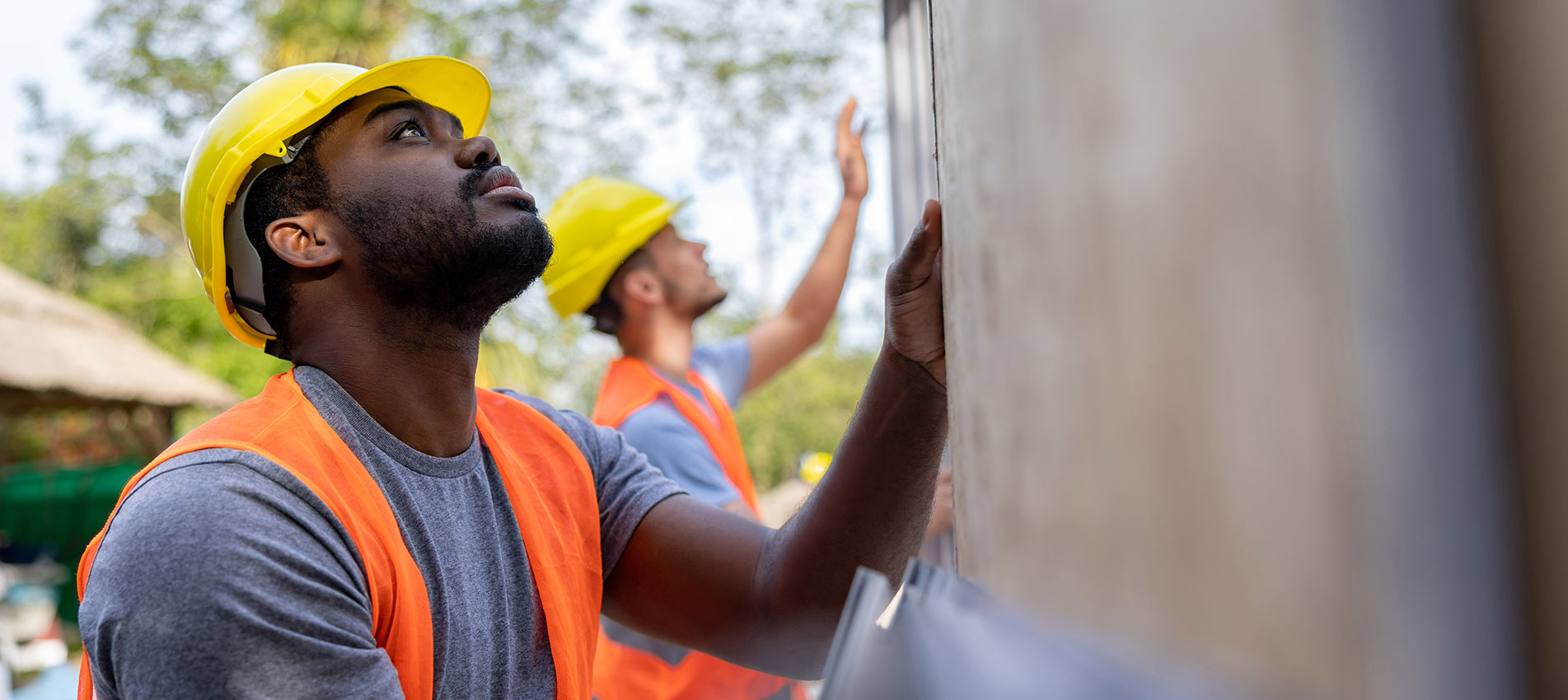 Construction Workers Installing Panels On A Building