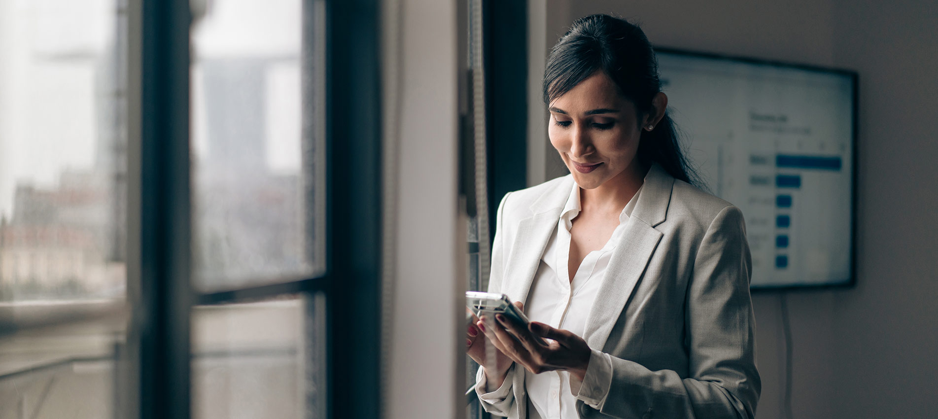 Indian Businesswoman Using Her Mobile Phone In The Office