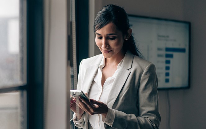 Indian Businesswoman Using Her Mobile Phone In The Office