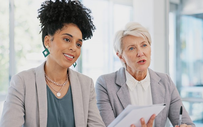 Management And Professional Workers In Discussion With Paperwork