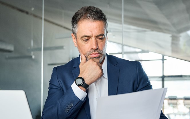 Serious Mid Aged Businessman Checking Corporate Financial Documents