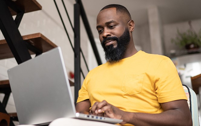 African America Man Using Laptop At Home