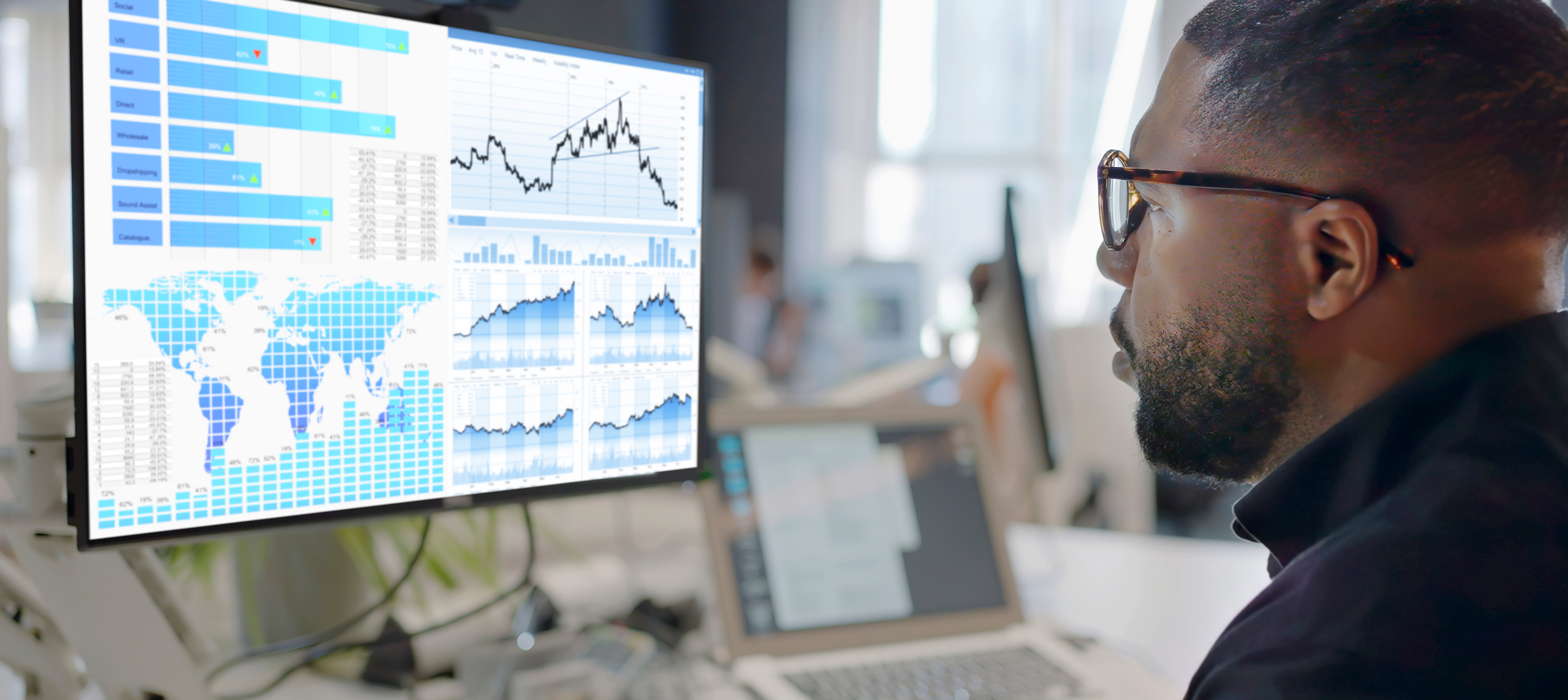 Man At Computer Looking At A Screen With US Data Chart