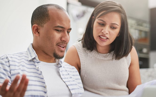 Young Couple Discussing Paperwork At Home