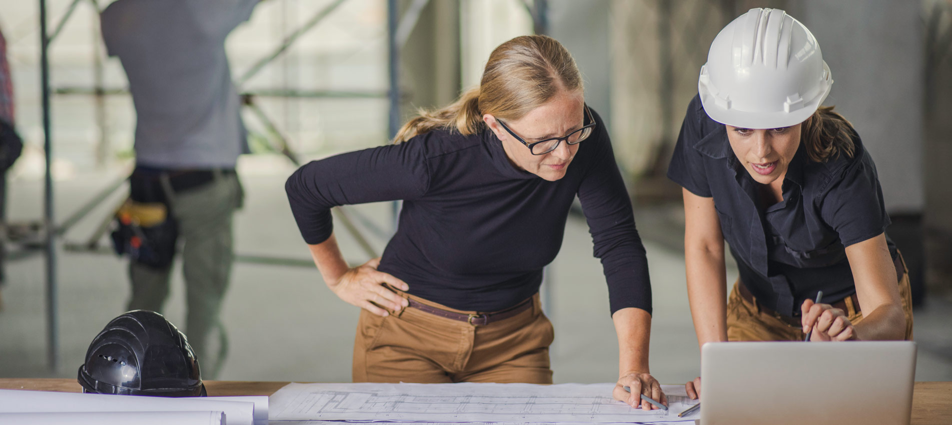 Female Constructor And Female Architect Reviewing Blueprints