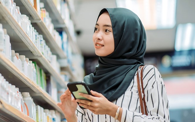 Asian Malay Female Smiling Customer Scouting Product At Shelf Of Pharmacy