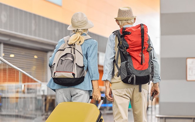 Two Caucasian Elderly Travelers Standing At The Airport