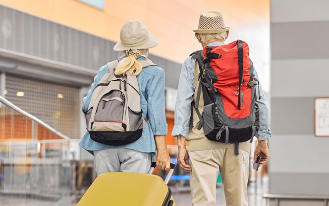 Two Caucasian Elderly Travelers Standing At The Airport