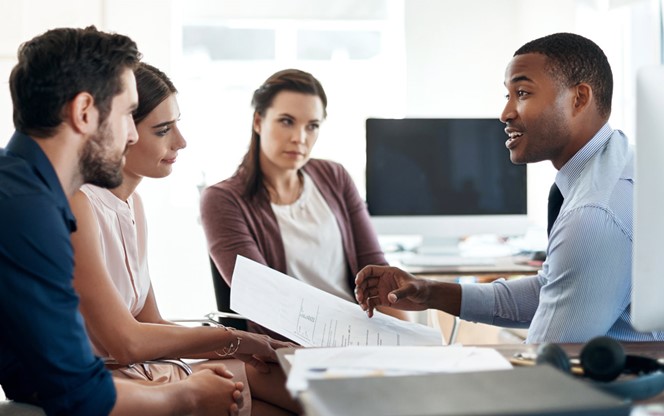 Group Of Colleagues Having A Discussion In A Modern Office