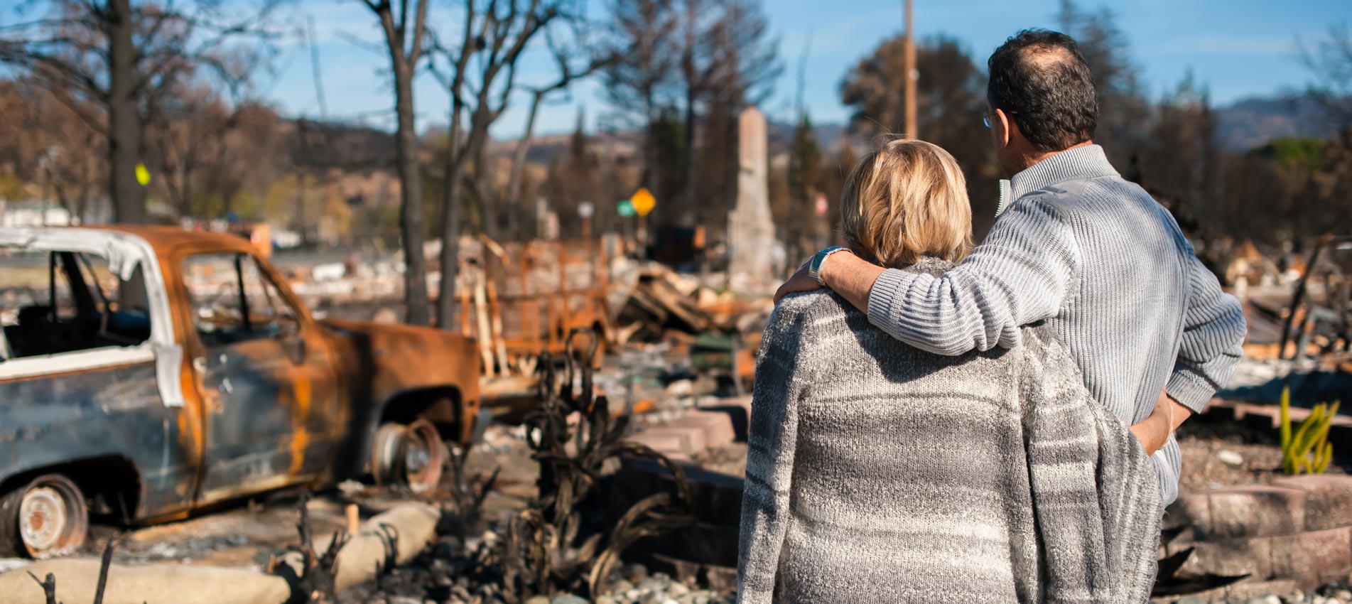 Senior Couple Checking Ruins After Fire Disaster