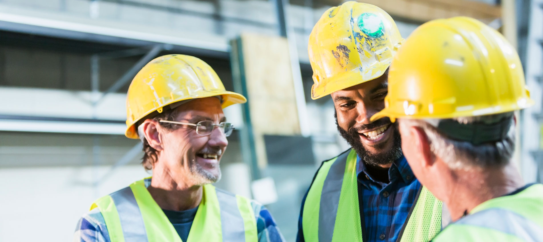 Three Multi Ethnic Workers With Safety Vests And Hard Hat
