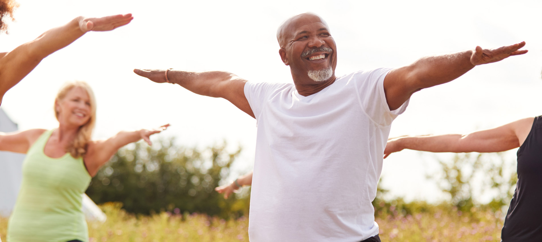 Mature Men And Women In Class At Outdoor Yoga Retreat