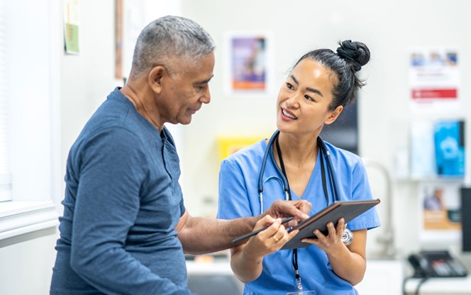 Hispanic Senior Man Having A Routince Checkup With An Asian Nurse