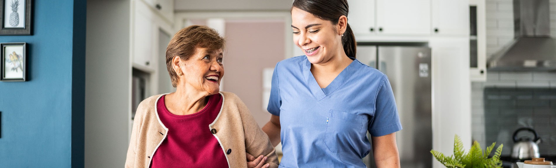 Home Caregiver Helping Senior Woman To Walk At House