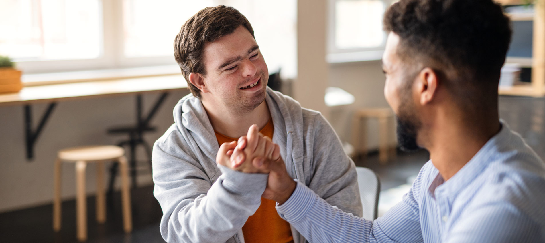 Young Happy Man With Down Syndrome With His Mentoring Friend