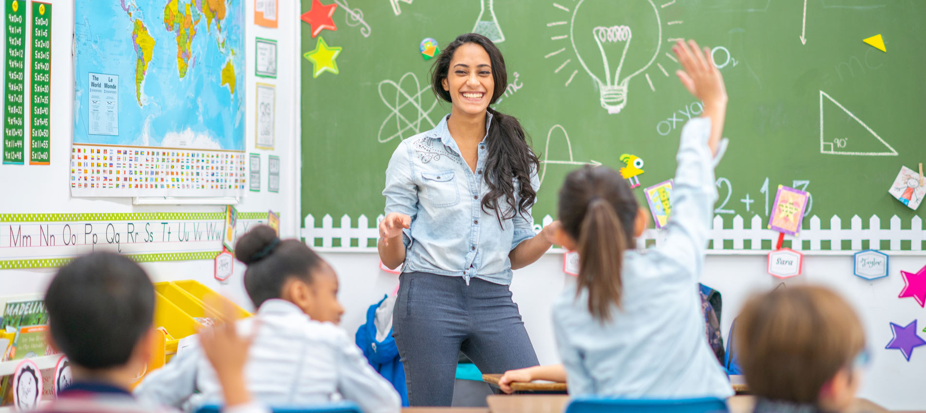 Middle Eastern Female Teacher Teaching Elementary Students In Classroom