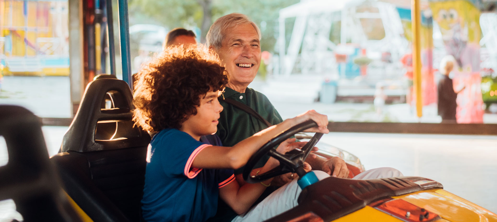 Grandpa And Grandson In A Bumper Car At The Amusement Park