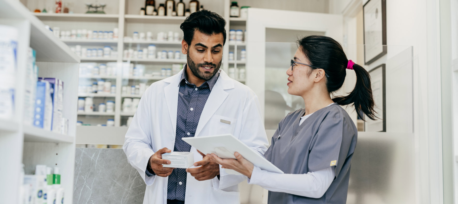 Male And Female Pharmacist Working In A Drugstore
